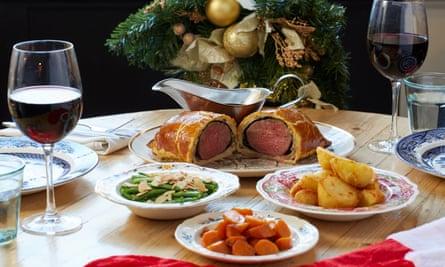 Roast dinner on a large table with two glasses of red wine at The Wellington, Fulham.